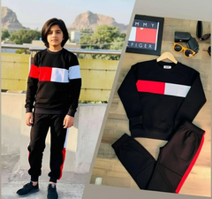 Black tracksuit with red and white stripes worn by a person outdoors, with a close-up of the tracksuit on a wooden surface.