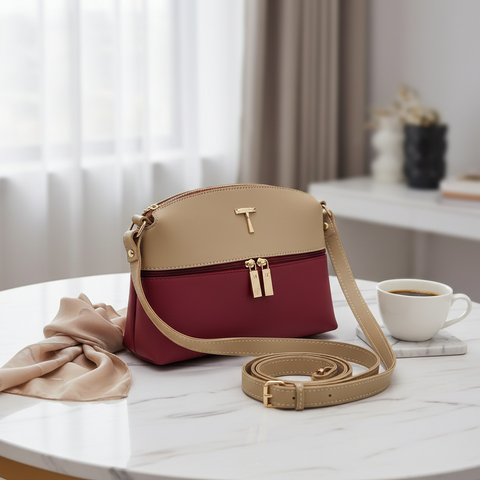 Two-tone handbag with beige top section and red bottom section on a table with a cup of coffee. For online Pakistan