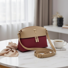 Two-tone handbag with beige top section and red bottom section on a table with a cup of coffee. For online Pakistan