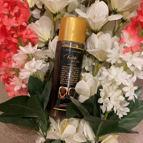 Hair oil bottle with gold cap surrounded by flowers