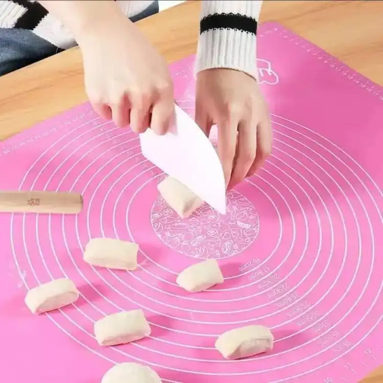 Person cutting dough on a pink silicone baking mat with a wooden knife. Online Sale In Pakistan