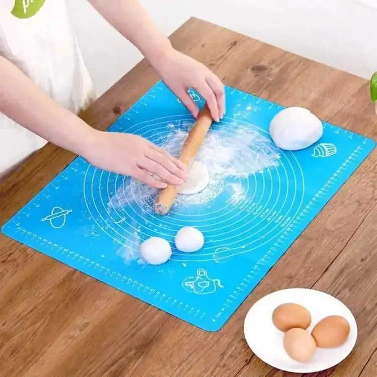Person using a blue baking mat with dough and a rolling pin on a wooden table. Online Sale In Pakistan 