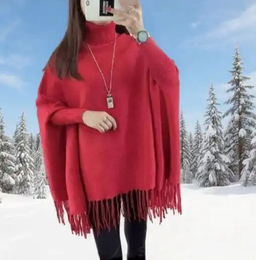 Person wearing a red poncho in a snowy landscape with trees.